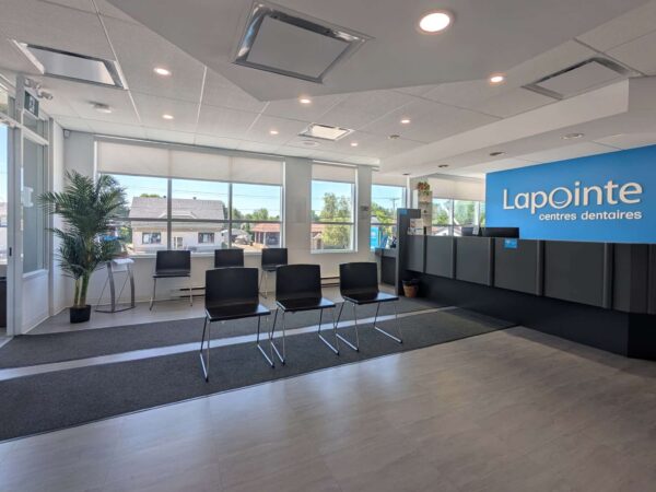 A modern reception area featuring a large window, a welcoming desk with the "Lapointe" sign, and several black chairs arranged neatly on a light-colored floor. A plant adds a touch of greenery to the space, creating a bright and inviting atmosphere.