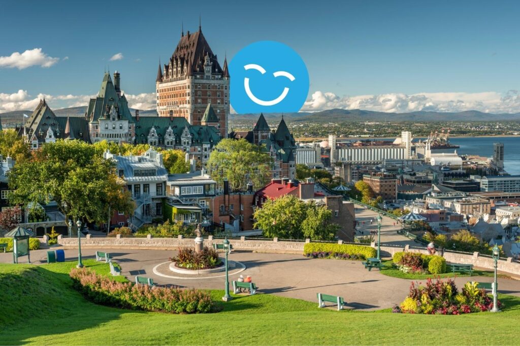 Une vue panoramique d'un paysage urbain vibrant avec des bâtiments historiques, une végétation luxuriante et un front de mer. La scène est lumineuse et accueillante, avec un ciel clair et une icône souriante joyeuse superposée au paysage.
