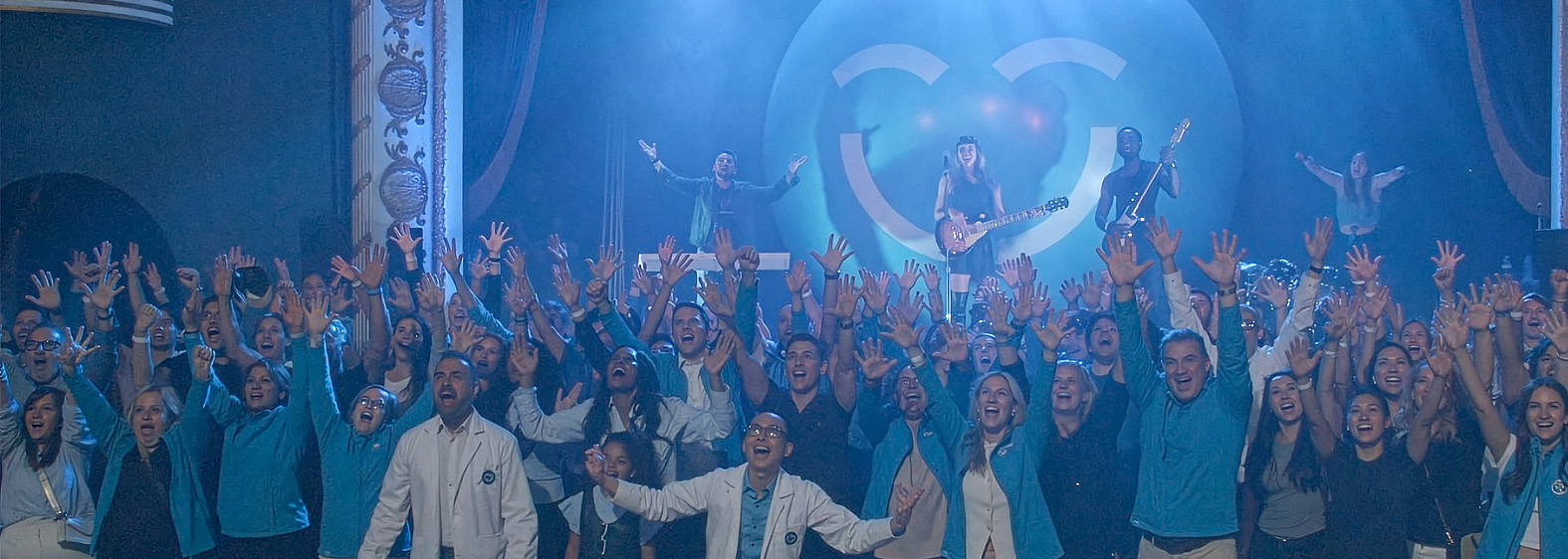 Une foule animée célèbre joyeusement le lancement de la campagne « Smiles Across Canada » (Des sourires à travers le Canada), levant les mains avec enthousiasme. À l'arrière-plan, un artiste joue de la guitare sur scène, accompagné d'un éclairage coloré et d'un grand smiley 123Dentiste qui ajoute une touche ludique à l'atmosphère.