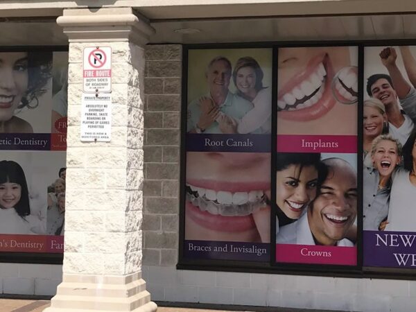 Dental clinic storefront with diverse, smiling faces and promotional signs highlighting services like implants and braces. A banner reads "New Patients Welcome."